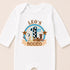 A white onesie with a graphic design featuring a cow, a horse, and a cowboy hat, along with the text "LEO'S 1ST RODEO".