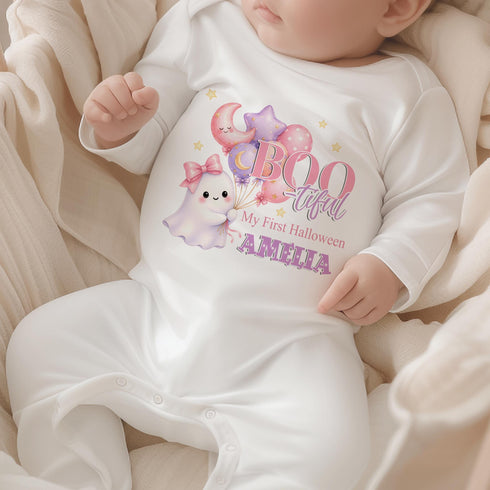 Personalised baby’s first Halloween white sleepsuit featuring a cute pastel ghost holding pink and purple balloons, stars and baby’s name.