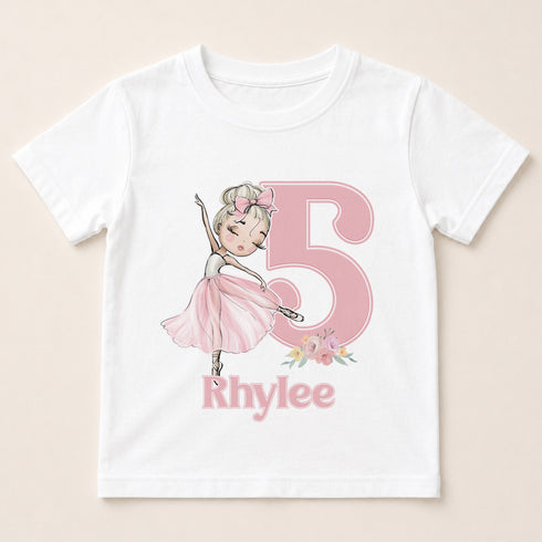 A white t-shirt with a pink illustration of a young girl dancing and the number 5 in pink. Below the number, the name "Rhylee" is written.