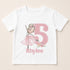 A white t-shirt with a pink illustration of a young girl dancing and the number 5 in pink. Below the number, the name "Rhylee" is written.