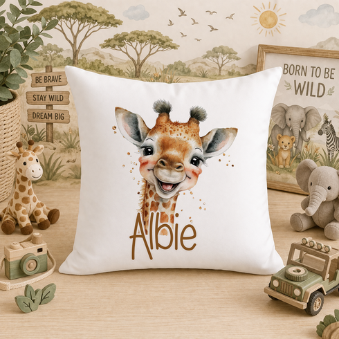 A white pillow with a giraffe image and the name "Albie" printed on it, surrounded by various stuffed animals and toys.