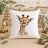 A white pillow with a giraffe image and the name "Albie" printed on it, surrounded by various stuffed animals and toys.