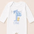 A white onesie with a blue number one and a yellow duck holding blue balloons, along with the name "Ollie" printed on it.