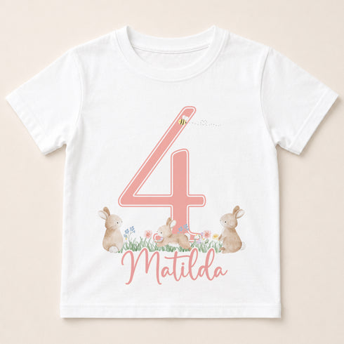 A white t-shirt with a pink number 4 and a bunny illustration, along with the name "Matilda" written below.