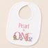 A white baby bib with a pink text and animal illustrations printed on it.