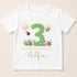 A white t-shirt with a graphic design featuring a large number 3 surrounded by various cartoon insects and animals, along with the text "Happy Birthday Alfie".