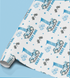 a roll of wrapping paper with a repeating pattern of blue balloons, racing cars, and stars.