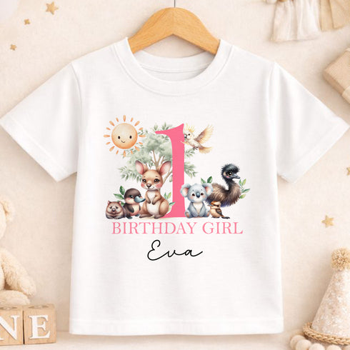 A white t-shirt with a pink number one and various animal illustrations, along with the text "BIRTHDAY GIRL Eva".