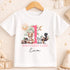 A white t-shirt with a pink number one and various animal illustrations, along with the text "BIRTHDAY GIRL Eva".