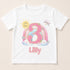 A white t-shirt with a personalized design featuring the number 3, flowers, and a sun.