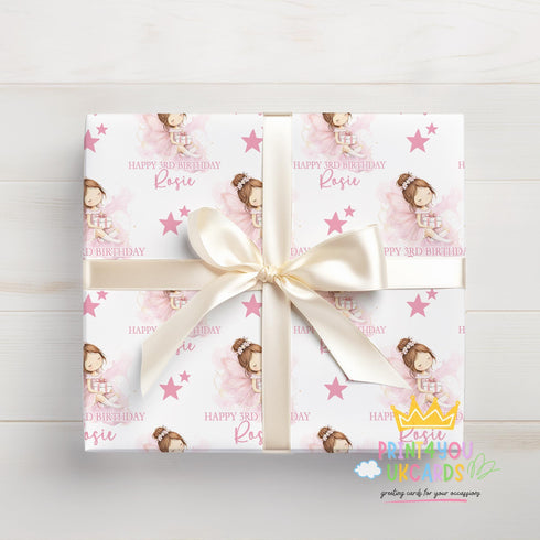 A gift box wrapped with a pink and white pattern featuring a princess and stars, tied with a white ribbon.