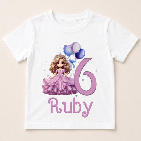 A white t-shirt with a graphic design featuring a princess wearing a purple dress and holding balloons, along with the text "Ruby" below the design.