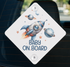 A sticker with a rocket ship and planets on a car window, along with the text "BABY ON BOARD".