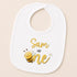 A white baby bib with a cartoon bee and the text "Sam is one" printed on it.