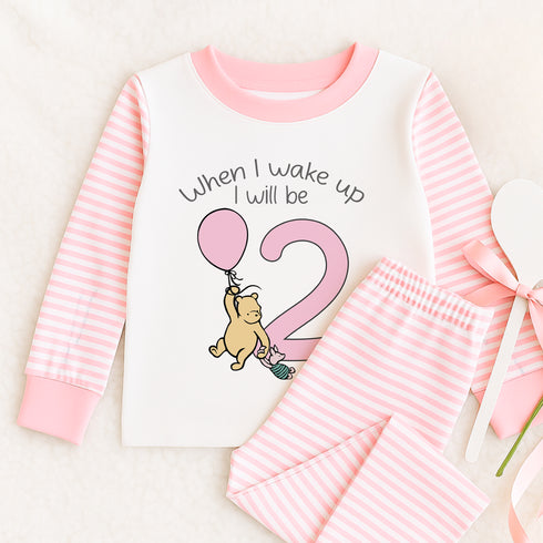 a baby girl's pajamas and shirt with a teddy bear on it