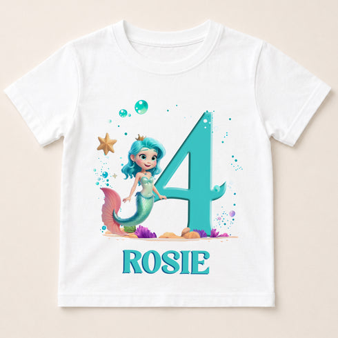 A white t-shirt with a design featuring a mermaid character and the number 4, along with bubbles and a starfish. The name "ROSIE" is written below the design.