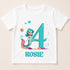 A white t-shirt with a design featuring a mermaid character and the number 4, along with bubbles and a starfish. The name "ROSIE" is written below the design.