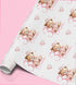 a roll of wrapping paper with a repeating pattern of teddy bears wearing crowns and the text "Madeline" written on them.