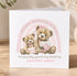 A greeting card with a pink and white color scheme, featuring two teddy bears sitting together and holding flowers. The card has a message that reads "Happy Mother's Day" and "I'm so lucky you're my Mummy" along with the name "Love from Jessica".