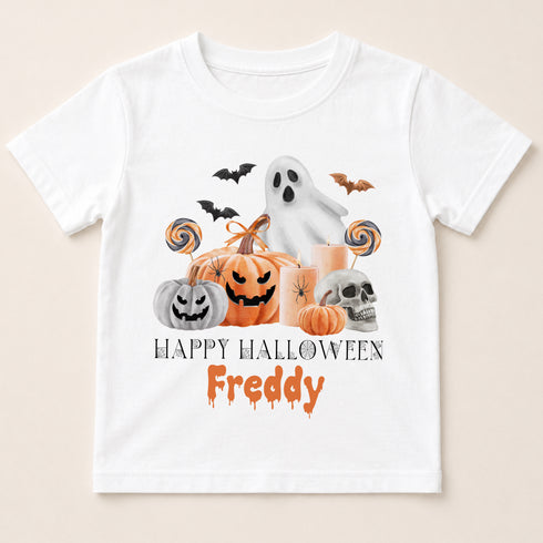A white t-shirt with a Halloween-themed graphic design featuring a ghost, pumpkins, a skeleton, and bats. The text below the graphic says "Happy Halloween Freddy".