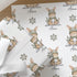 Personalised Christmas wrapping paper featuring a cute winter bunny rabbit wearing a knitted hat and scarf, custom name Christmas gift wrap with festive snowflakes.