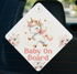 A diamond-shaped sign with a cartoon unicorn and the text "Baby On Board" printed on it.