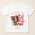 A white t-shirt with a graphic design featuring a cartoon image of a young girl wearing a cowboy hat and standing next to a horse, along with the text "Birthday Girl 4" and "Elisa" printed on it.