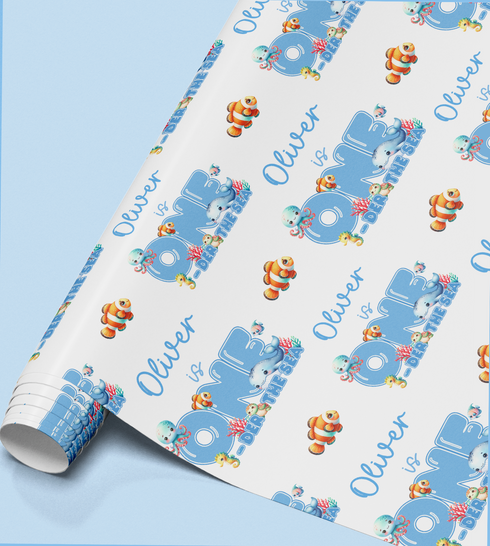 The image is a roll of wrapping paper with a repeating pattern of the name "Oliver" and various sea creatures, such as fish and octopuses, printed on it.