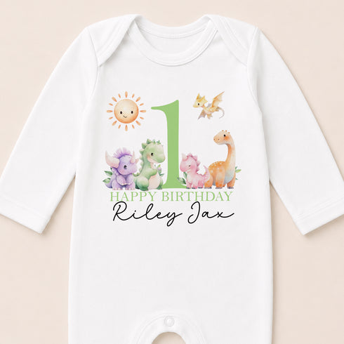 A white onesie with a personalized birthday message and cartoon animal illustrations.