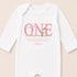 A white onesie with a pink text and an illustration of a rabbit on it.