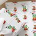 Close-up of personalised Christmas dinosaur wrapping paper featuring a cute T-Rex wearing a Santa hat with festive presents on premium white gift wrap.