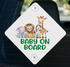a sticker with a cartoon illustration of a lion, giraffe, and elephant, along with the text "BABY ON BOARD" written on it.