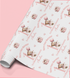 a roll of wrapping paper with a repeating pattern of a teddy bear and a gift box, along with the text "Happy First Birthday" and "Amanda" printed on it.