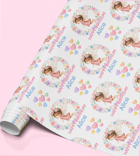 Personalised fairy birthday wrapping paper featuring a pretty fairy, floral wreath, pastel hearts and custom name for girls.