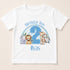 A white t-shirt with a graphic design featuring a blue number 2 surrounded by various cartoon animal characters, including a lion, zebra, giraffe, and elephant. The text "Birthday Boy 2" is written above the number, and "Ilyas" is written below the number.