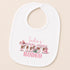 A white baby bib with a pink and white design featuring the text "Indie's First Rodeo" and various western-themed elements such as a cowboy hat, boots, and a lasso.