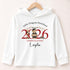 White lightweight hooded long-sleeved T-shirt with a personalised teddy bear preschool graduation 2026 design, displayed on a wooden hanger.