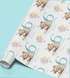 a roll of wrapping paper with a repeating pattern of a teddy bear wearing a party hat and holding a birthday cake, along with colorful balloons.