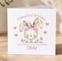 A white greeting card with a cute bunny illustration and a personalized message for a first birthday celebration.