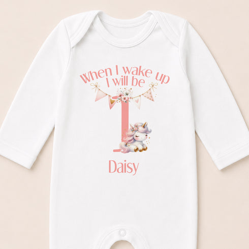 A white onesie with a personalized text and a small unicorn graphic printed on it.