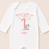 A white onesie with a personalized text and a small unicorn graphic printed on it.
