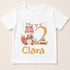 A white t-shirt with a cartoon fox and a birthday cake, along with the name "Clara" printed on it.
