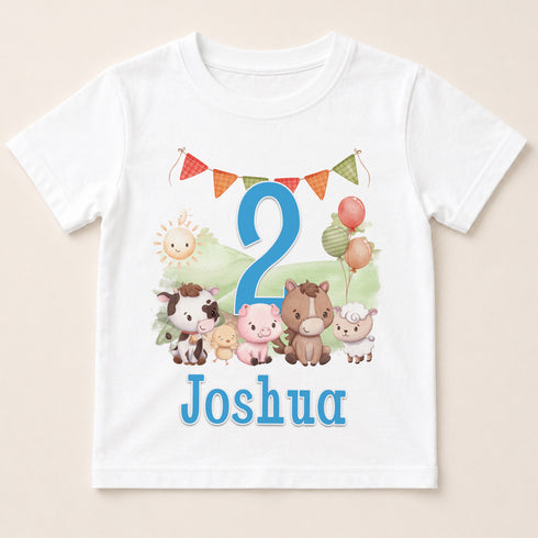 A white t-shirt with a cartoon image of various animals, including a horse, cow, pig, sheep, and a sun, along with a number 2 and the name " Joshua" printed on it.