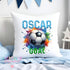 White soft plush cushion with a personalised name in a bold blue colour. there is a black and white football with a very bold and colourful splashy background behind it and the word GOAL in green under neath