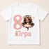 A white t-shirt with a graphic design featuring a fairy-like character and the number 8, along with the text "Kirpa" below the number.
