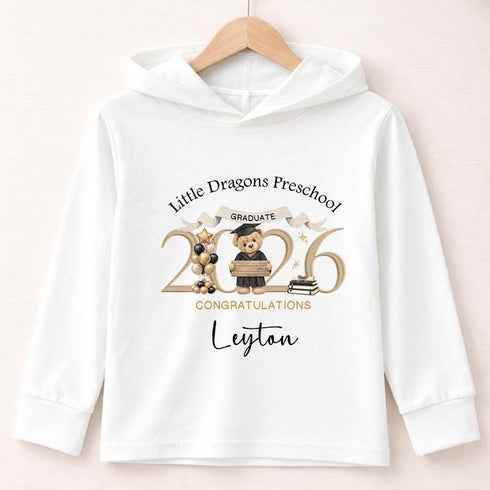 White lightweight hooded long-sleeved T-shirt featuring a personalised gold 2026 teddy bear preschool graduation design with a child’s name and preschool name.