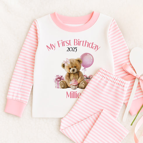 a baby girl's first birthday outfit with a teddy bear