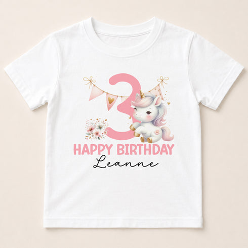A white t-shirt with a pink unicorn and the number 3 printed on it, along with the text "Happy Birthday Leanne".