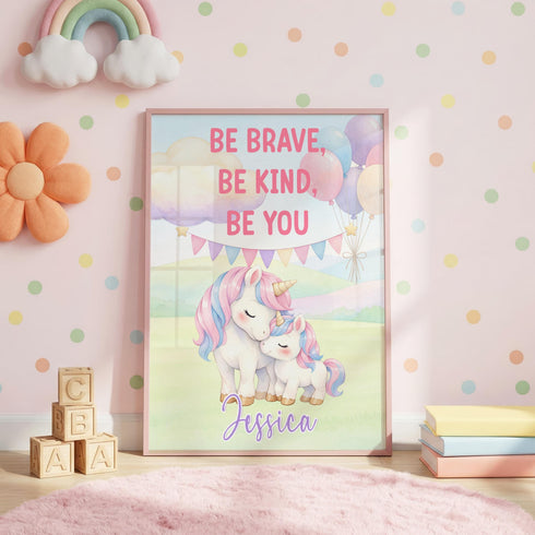 Personalised unicorn nursery poster with pastel rainbow colours, “Be Brave, Be Kind, Be You” wording and the name Jessica, shown framed in a pink child’s bedroom.