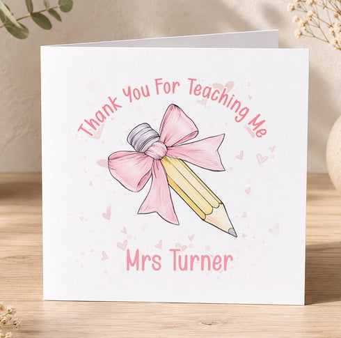 A white card with a pink bow and a pencil, along with the text "Thank You For Teaching Me" and "Mrs Turner" written on it.